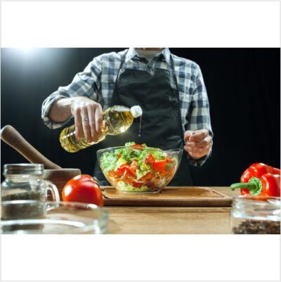 تصویر با کیفیت مرد در حال درست کردن سالاد و روغن زیتون