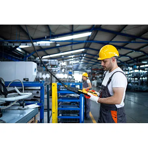 factory worker wearing uniform hardhat operating industrial machine with push button joystick 1 تصویر